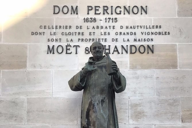 The statue of Dom Pérignon before the stone inscription naming him cellarer of the abbey of Hautvillers, 1638-1715