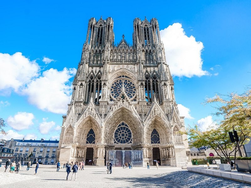 Reims Cathedral's west front and its rose window under a blue sky